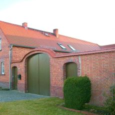 Bauernhof mit Wohnhaus, Seitengebäude und Hofmauer mit einem großen Torbogen und zwei kleinen Pforten, dazu Feldscheune Dorfstraße 61