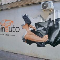 Mural en la sede de la empresa de tintado de lunas Laminauto. El mural representa a un operario tintando las lunas de un vehículo.