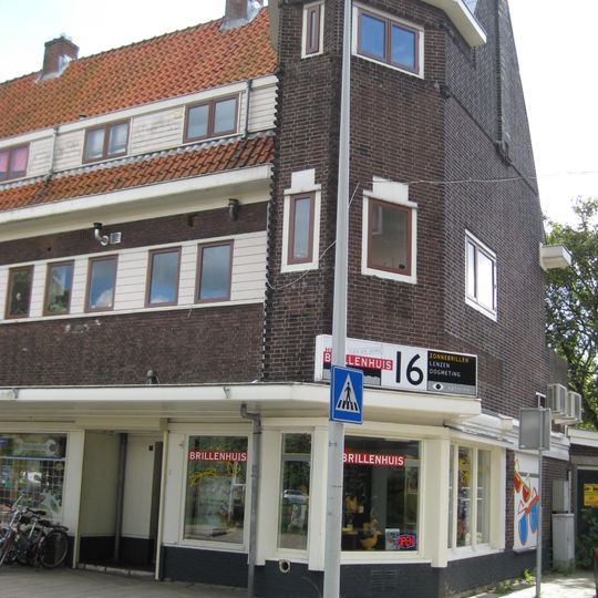 Blok met winkels met brede luifel en daarboven woningen, bouwstijl Amsterdamse School, onderdeel van het centrale achthoekige plein van Tuindorp Nieuwendam