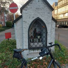 In dem Bildstock befindet sich eine Marienstatue. Er ist zwar öffentlich zugänglich, liegt aber auf einer Verkehrsinsel in der Mitte einer Straße und an einem stark befahrenen Radweg entlang der Dürener Straße.