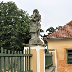 Alegorická socha Leden v ohradě zámecké zahrady ve Veltrusech