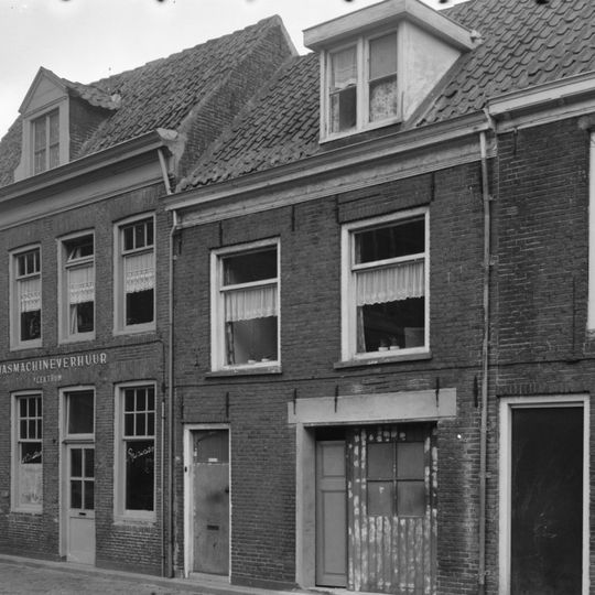 Pand met gepleisterde klokgevel met beginvoluten en tympaanbeëindiging