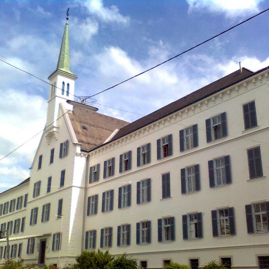 Kirche und Konvent der Schwestern vom Hl. Kreuz mit Zaun und Lourdes Grotte