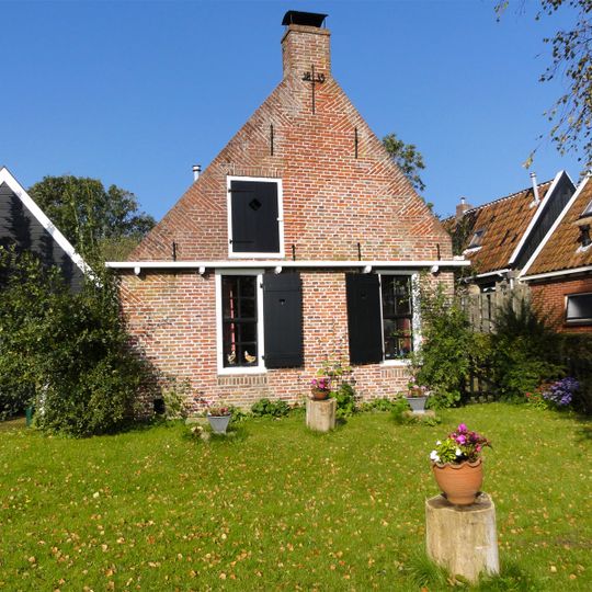 Pand met puntgevel met zesruitsschuiframen en venster met luiken onder zadeldak