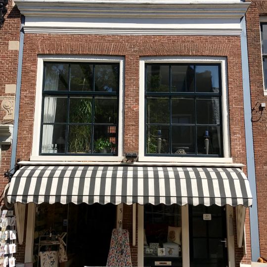 Lage tussenbouw met recht geprofileerde kroonlijst en twee negenruitsvensters