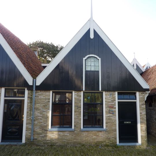 Eenvoudig pand met houten voorschot, is eigenlijk geen zelfstandig adres, maar een gedeelte van nummer 20