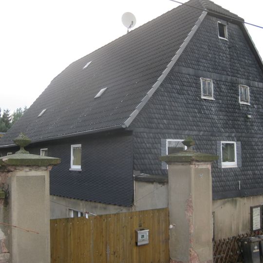 Wohnstallhaus und Einfriedungsmauer mit Toreinfahrt eines ehemaligen Dreiseithofes Ortelsdorfer Straße 21