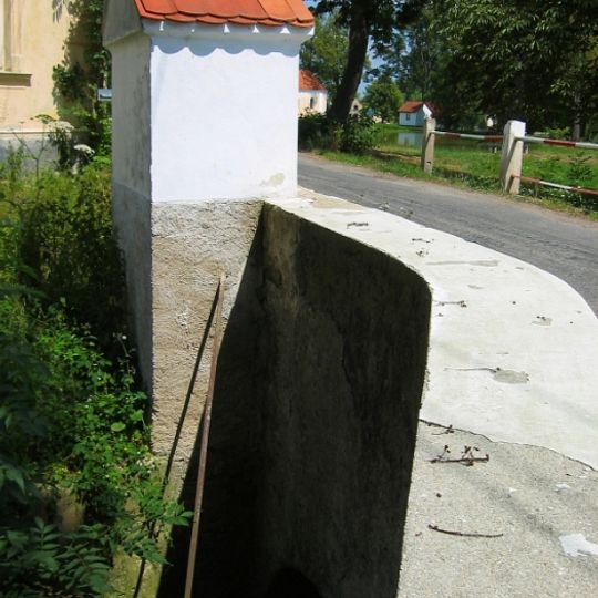 Most silnice III/14718  na západní straně návsi v Mažicích