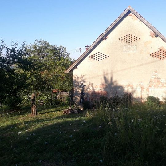 Kříž u zdi domu ve Vrážném