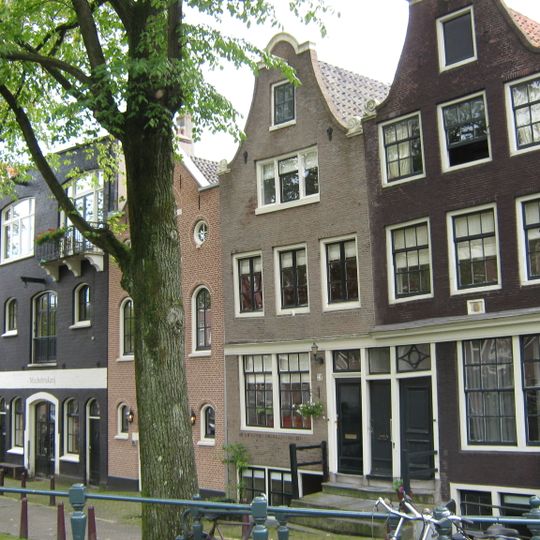 Huis waarvan de gevel wordt beëindigd door een klokvormige top onder rollagen