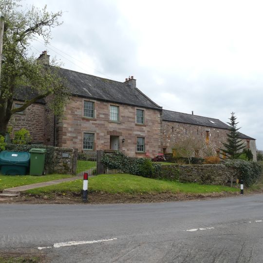Farmhouse and attached barn on west side of road at north end of village