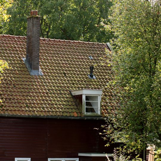 Houten ingenieurswoning onder met Hollandse pannen gedekt zadeldak