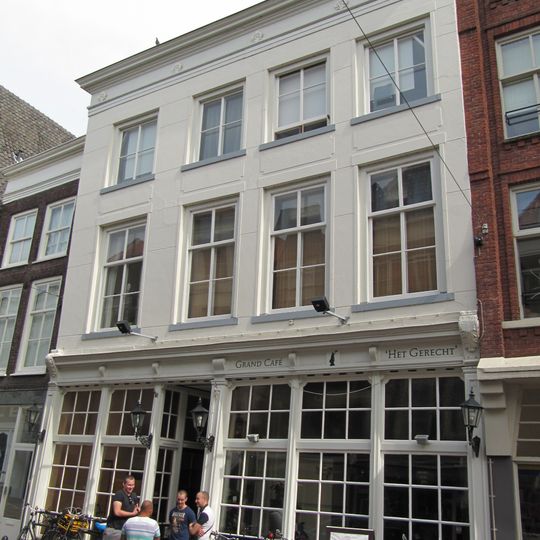 Pand achter brede gepleisterde lijstgevel ter breedte van vier vensters