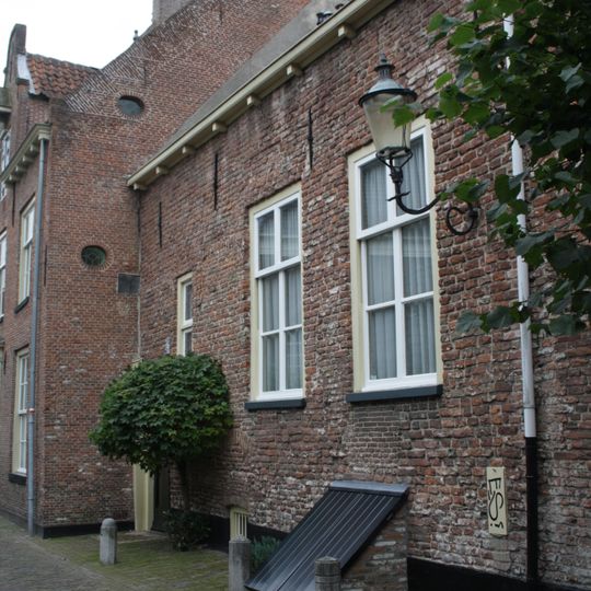 Laag, eenvoudig woonhuis, aan singelzijde gepleisterd. Rechte lijst. Het oude muurwerk van de stadsmuur duidelijk zichtbaar. Vormt een geheel met nr 11