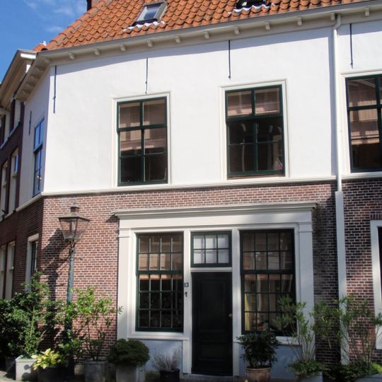 Huis op onregelmatig grondvlak, onder schilddak. Bovenste helft gevel gepleisterd. Goede roedenverdeling in de vensters