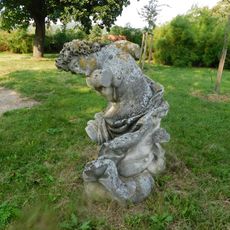 Socha klečící postavy v zámeckém parku ve Slavkově