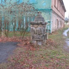 Podstavec ulomeného kříže na návsi v Ostrém