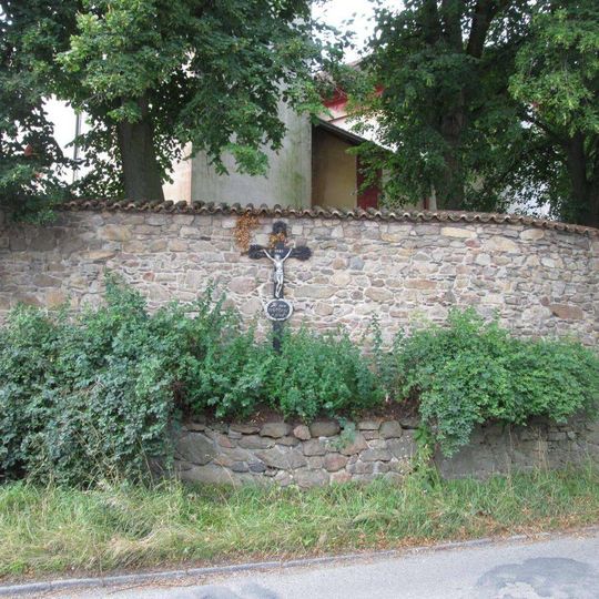 Kříž u kostela na zdi v Neveklově