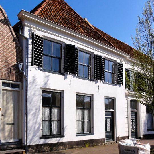 Pand met gewitte lijstgevel met zandstenen leeuwenmaskers