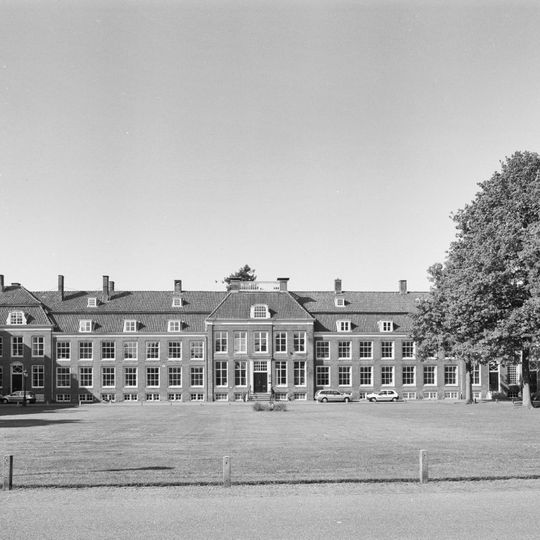 Pand met vooruitspringende sobere lijstgevel, dak door schoorstenen bekroond