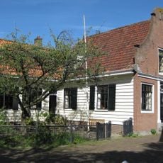 Houten huis met bakstenen halsgevel uit 1768 en houten puntgevel aan zijkant