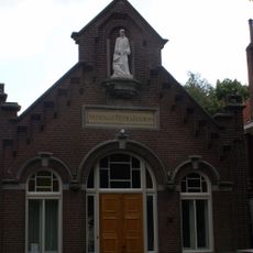 Patronaatsgebouw aan De Schans, baksteen met knipvoeg opgetrokken eenlaags gebouw onder zadeldak