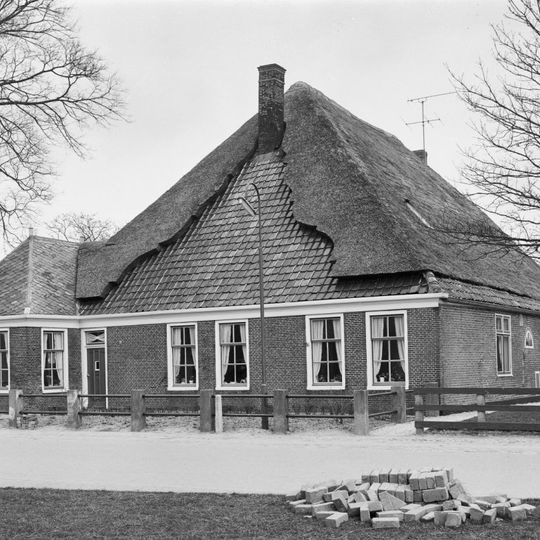 Stolphoeve met links een uitbouwtje onder een met leien gedekt schilddak. Zesruitsschuifvensters