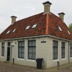 Eenvoudige hoekwoning onder zadeldak