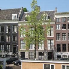 Huis achter gezamenlijke gevel met nr 25, onder rechte lijst, dwars dak en dakkapel