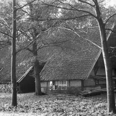 Twee fraai op het erf gesitueerde, forse vakwerkschuren, een met twee dwarsdoorritten, de ander met inrijdeuren in de smalle gevel