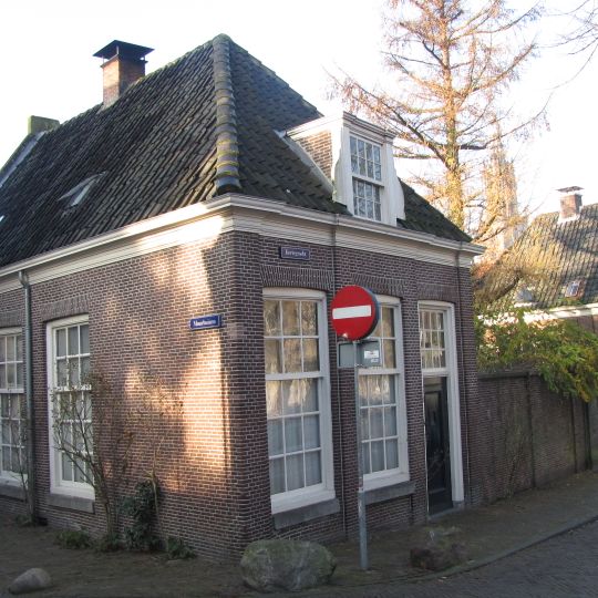 Woonhuis, waarvan de voor- en zijgevel in baksteen zijn uitgevoerd. Zijgevel met spaarnissen. Maakt deel uit van het synagoge-complex