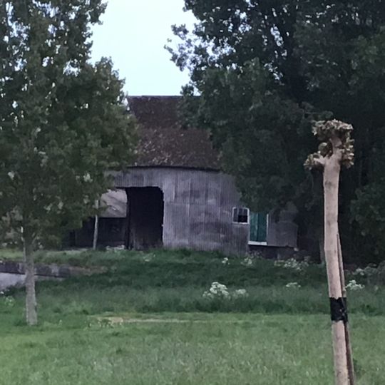 Houten schuur met hooizolder onder met golfplaten gedekt mansardedak