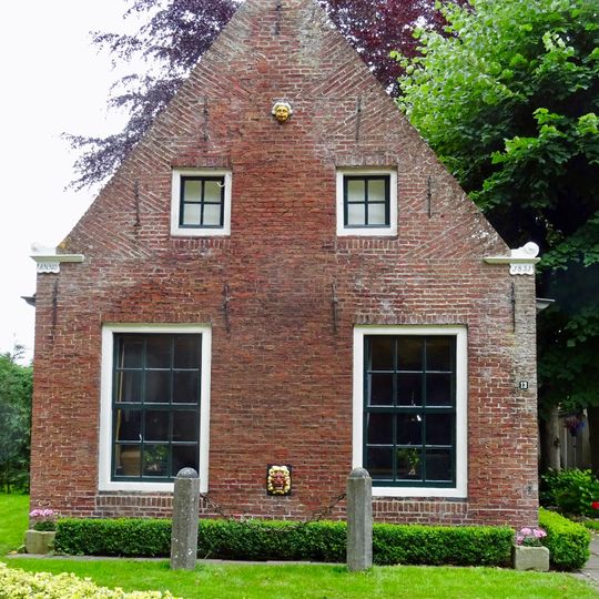 Pandje met twaalfruitsvensters onder zadeldak tegen topgevels met vlechtingen in kopjes