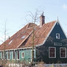 Houten boerderij, achter het woonhuis een vierkante stal met hoog dak