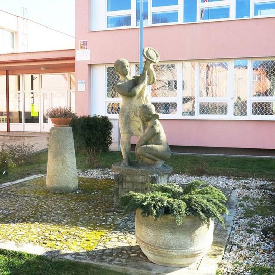 Socha dívek se slunečnicí u školy v Školní ulici v Kadani