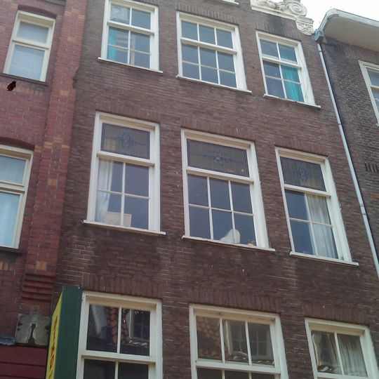Huis, vanwege de zandstenen vleugelstukken van de gevelhals