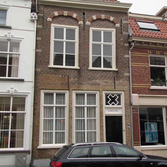 Huis met lijstgevel waarin geprofileerde tooglijsten op maskers plat dak