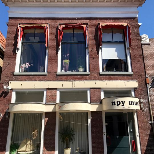 Pand met rechte kroonlijst en etalage in pui onder schilddak met originele frontschoorsteen