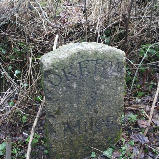 Milestone, 20m E of small bridge at bottom of hill, 300m W of drive to Yelland Farm