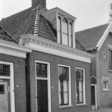 Pand met zesruitsvensters onder zadeldak met voorschild waarboven topschoorsteen met bord en drielichtsdakkapel