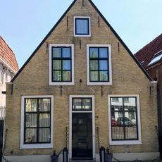 Laag pand onder zadeldak tegen topgevel