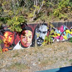 Mural que presenta el retrata de tres cantantes de hip hop.