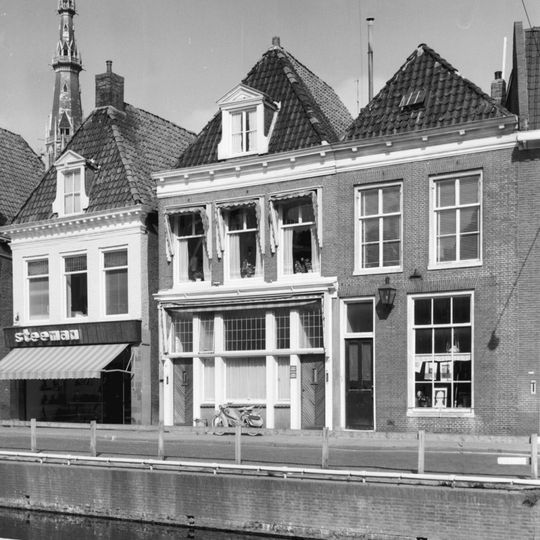 Pand met aangepaste pui en rechte kroonlijst met blokjes onder zadeldak met voorschild