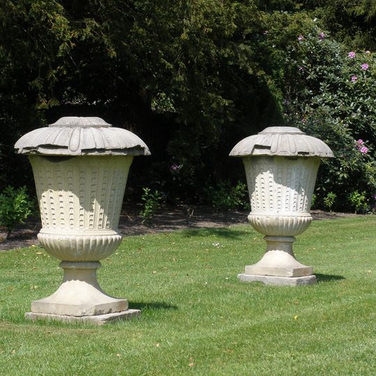 Twickel: natuurstenen urnvormige tuinvazen rozentuin net deksel op voetplaat, rijk gedecoreerd in relief