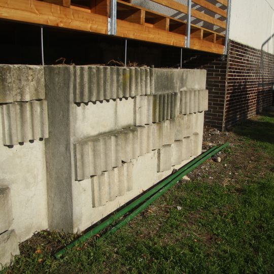 Betonové žardiniéry před obchodním střediskem sídliště Hájek