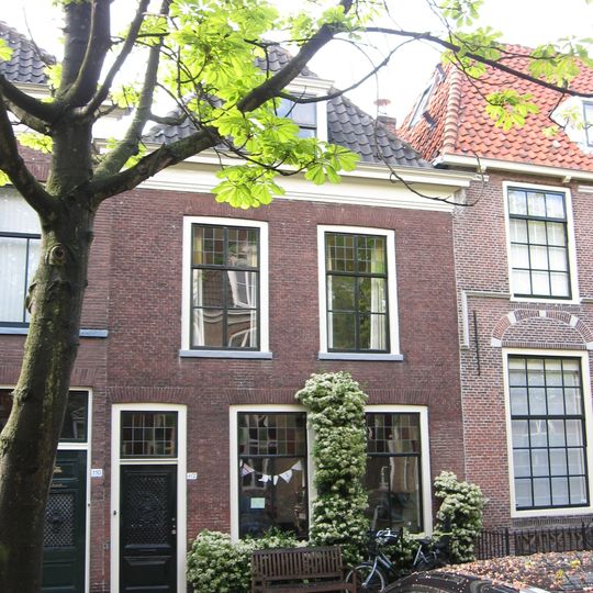 Pand onder schilddak en met eenvoudige lijstgevel. In de verdieping zesruits-schuiframen