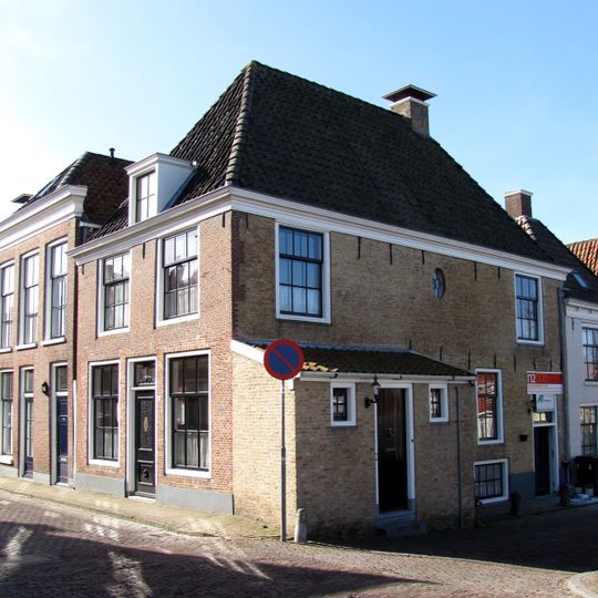 Eenvoudig woonhuis met gepleisterde gevel onder schilddak