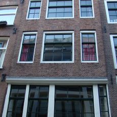 Huis met gevel op karakteristieke hoge houten pui en latere punttop