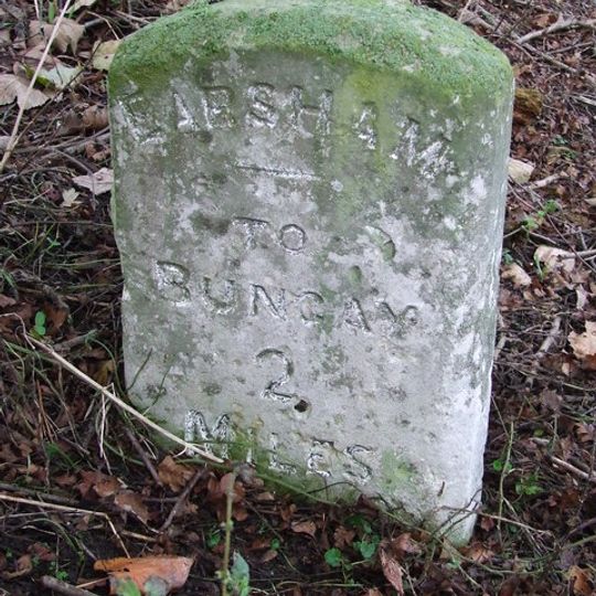 Milestone, Old Harleston Rd, 90yds W of entrance