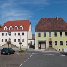 Wohnhaus (mit Freitreppe) in offener Bebauung und seitlichem Torbogen Markt 4